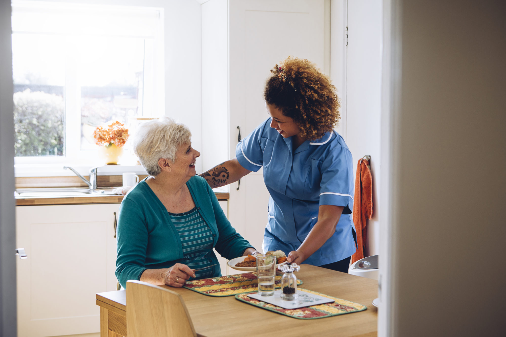 A TC Care worker supporting a client with a meal at home